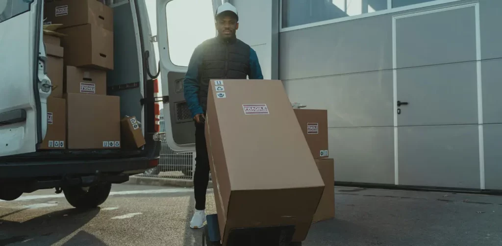 A Man Efficiently Loading Boxes Into A Van, Ready For A Delivery