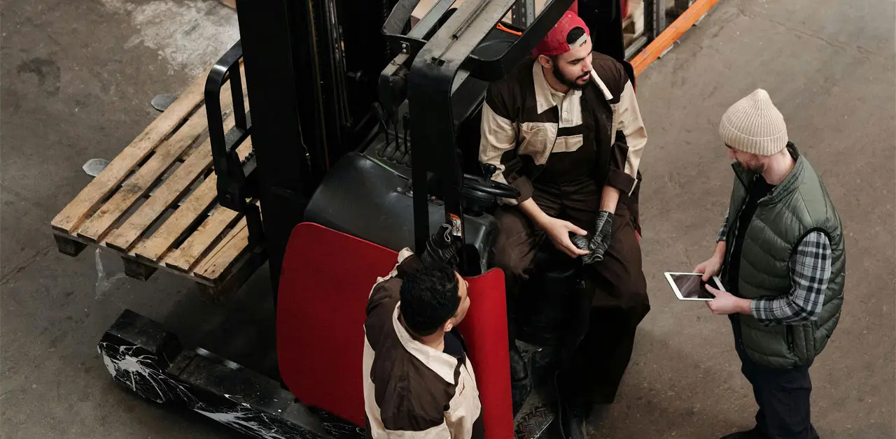 A Forklift Maneuvering Through A Warehouse, Surrounded By Shelves Stacked With Boxes And Goods