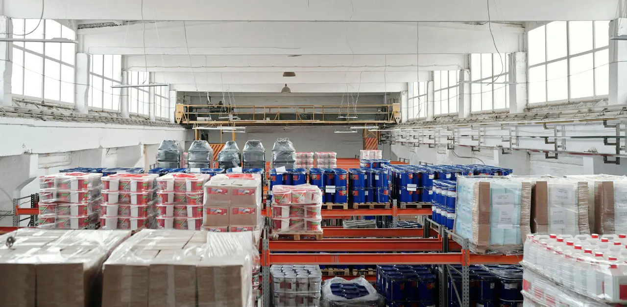 A Warehouse Interior Filled With Stacked Boxes Of Various Sizes, Creating A Busy And Organized Storage Environment
