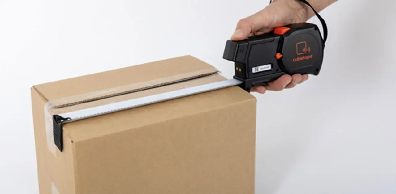 A Person Measuring A Box With A Tape Measure, Focusing On The Dimensions For Accurate Measurement