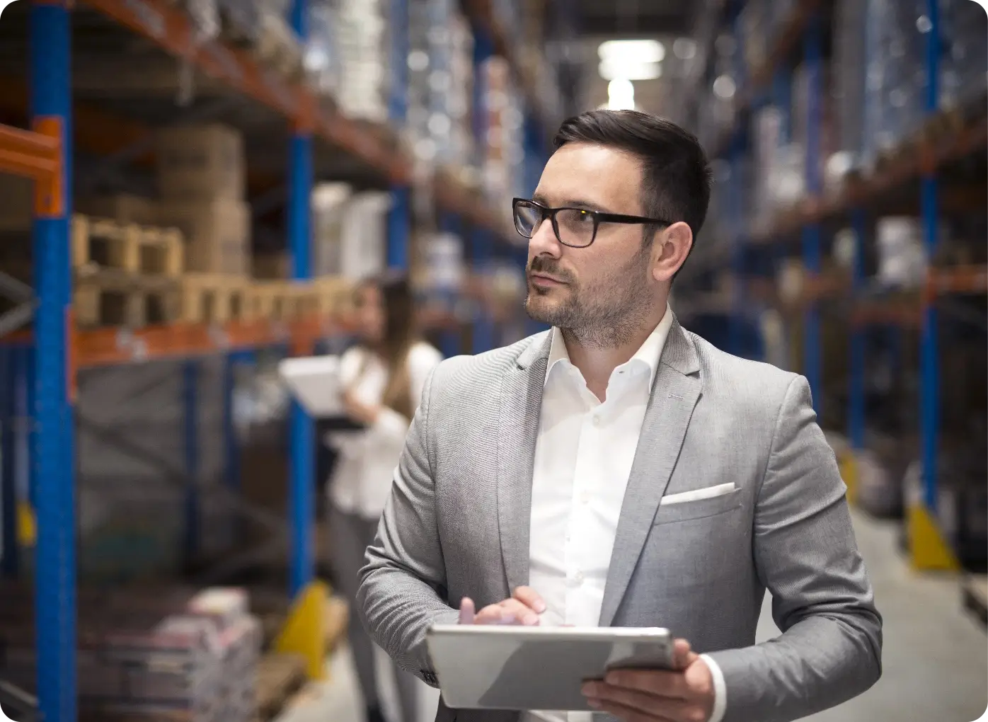 Portrait Successful Businessman Manager Ceo Holding Tablet Walking Through Warehouse Storage Area Looking Towards Shelves